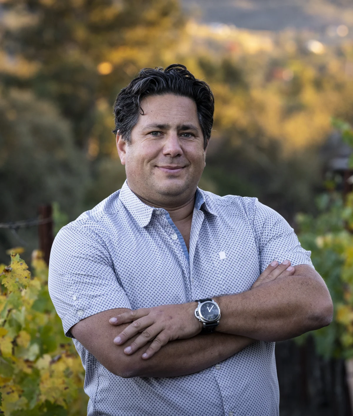Winemaker Julien Fayard with arms crossed among autumn vines