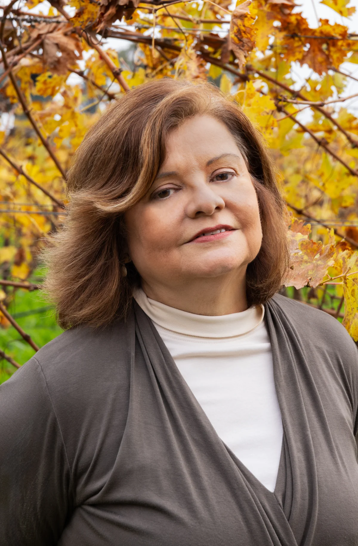 Sylvia Taplin among golden autumn grape leaves